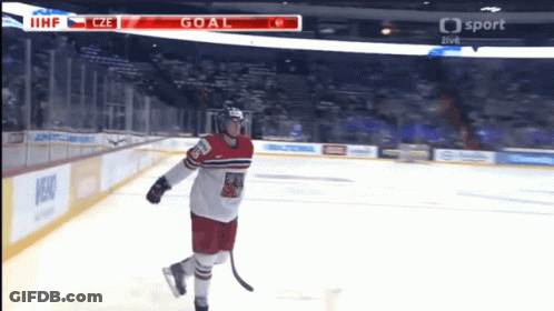 A Hockey Player Stands On The Ice With The Scoreboard Showing The Goal GIF