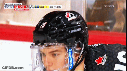 A Hockey Player Wearing A Bauer Helmet Looks Down At Something GIF