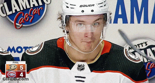 A Hockey Player Wearing A Bauer Helmet Stands In Front Of A Scoreboard GIF
