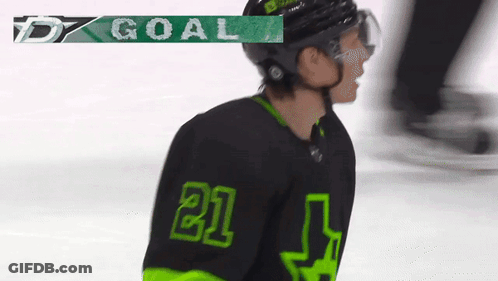 A Hockey Player Wearing A Black And Green Jersey With The Number 21 GIF