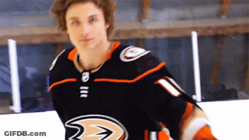 A Hockey Player Wearing A Black And Orange Jersey With A Ducks Logo On It GIF
