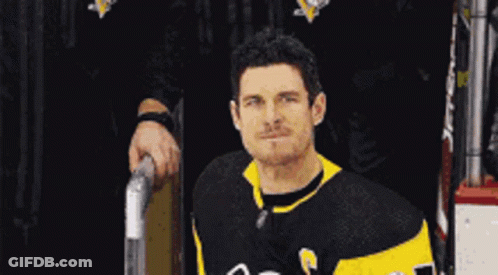 A Hockey Player Wearing A Black And Yellow Jersey With The Number 23 On It GIF