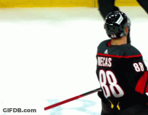 A Hockey Player Wearing A Black Jersey With The Number 88 On The Back GIF