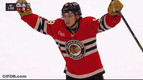 A Hockey Player Wearing A Blackhawks Jersey Is Holding A Hockey Stick GIF