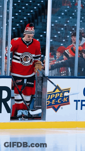 A Hockey Player Wearing A Blackhawks Jersey Is Standing On The Ice GIF