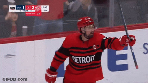 A Hockey Player Wearing A Detroit Jersey Is Holding A Hockey Stick GIF