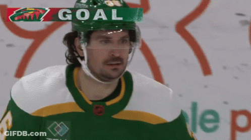 A Hockey Player Wearing A Green And White Jersey With The Word Goal Above Him GIF