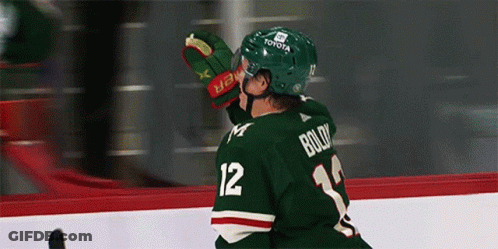 A Hockey Player Wearing A Green Jersey With Boldy On The Back GIF