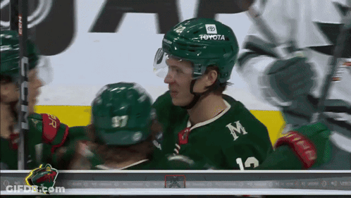 A Hockey Player Wearing A Green Jersey With The Letter M On It GIF