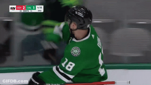 A Hockey Player Wearing A Green Jersey With The Number 18 GIF