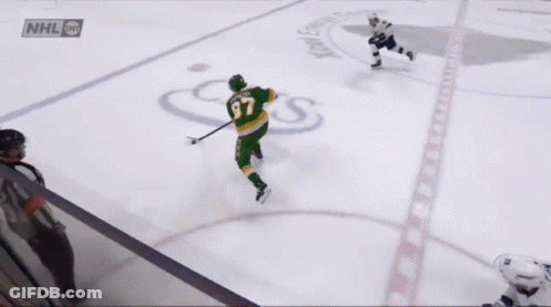 A Hockey Player Wearing A Green Jersey With The Number 37 GIF