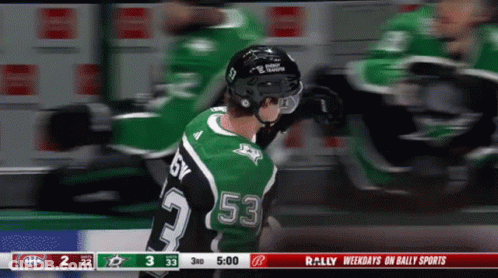 A Hockey Player Wearing A Green Jersey With The Number 53 On It GIF