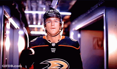 A Hockey Player Wearing A Helmet And A Jersey That Says Ducks Sticking Out His Tongue GIF