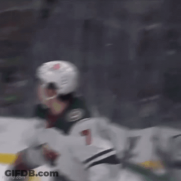 A Hockey Player Wearing A Helmet Is Flying Through The Air While Playing Ice Hockey . GIF