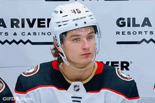 A Hockey Player Wearing A Helmet With The Number 46 On It . GIF