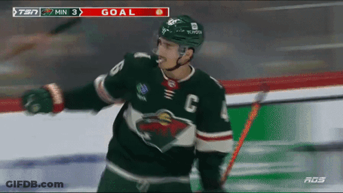 A Hockey Player Wearing A Jersey With The Letter C On It Celebrates A Goal GIF