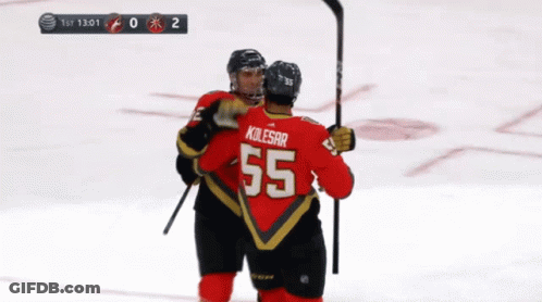 A Hockey Player Wearing A Number 55 Jersey Is Hugging Another Player GIF