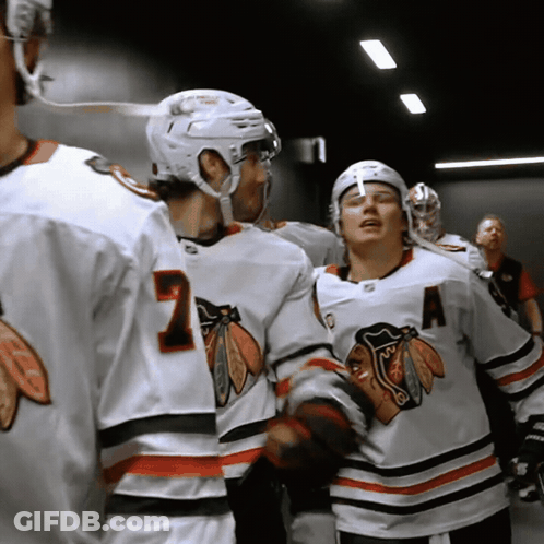 A Hockey Player Wearing A Number 7 Jersey Talks To Another Player GIF