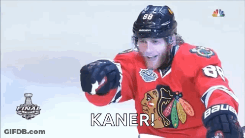 A Hockey Player Wearing A Red Jersey And A Black Helmet Is Standing On The Ice And Smiling . GIF