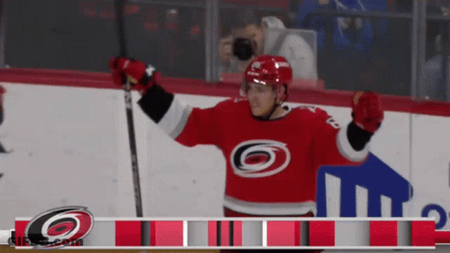 A Hockey Player Wearing A Red Jersey With A Black And White Circle On It GIF