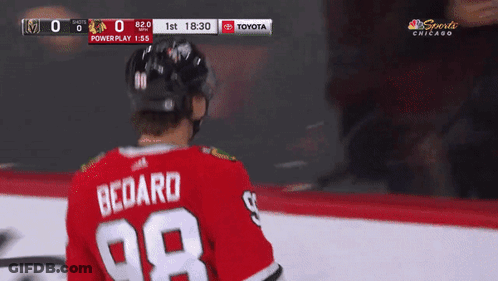 A Hockey Player Wearing A Red Jersey With The Number 98 On The Back GIF