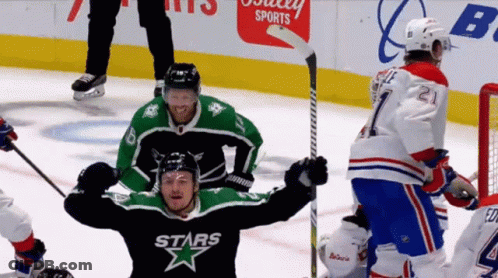 A Hockey Player Wearing A Stars Jersey Holds His Arms In The Air GIF