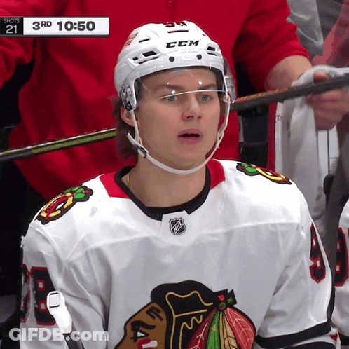 A Hockey Player Wearing A White Ccm Helmet Looks At The Camera GIF
