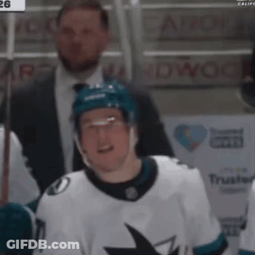 A Hockey Player Wearing A White Jersey With A Shark On The Front GIF