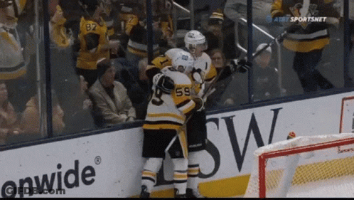 A Hockey Player Wearing Number 59 Hugs Another Player GIF