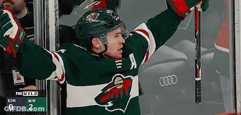 A Hockey Player With His Arms In The Air And A Scoreboard Behind Him That Says Fox Wild GIF