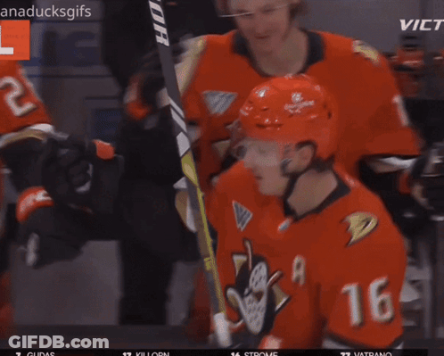 A Hockey Player With The Number 11 On His Helmet Is Hugging Another Player GIF