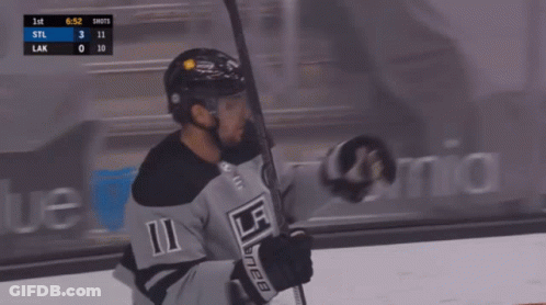 A Hockey Player With The Number 11 On His Jersey Is Holding A Hockey Stick GIF