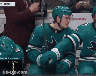 A Hockey Player With The Number 11 On His Jersey Stands In Front Of A Scoreboard GIF