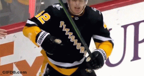 A Hockey Player With The Number 12 On His Jersey Is Holding A Hockey Stick GIF