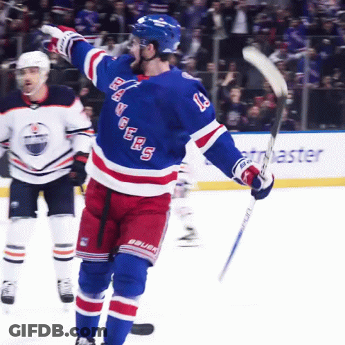 A Hockey Player With The Number 13 On His Jersey Holds Up His Stick GIF