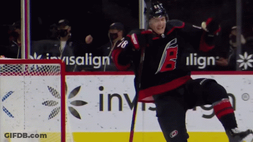 A Hockey Player With The Number 18 On His Jersey Celebrates His Goal GIF