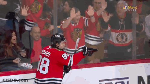 A Hockey Player With The Number 18 On His Jersey Is Celebrating GIF