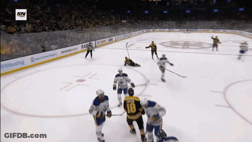A Hockey Player With The Number 18 On His Jersey Stands On The Ice Surrounded By His Teammates GIF