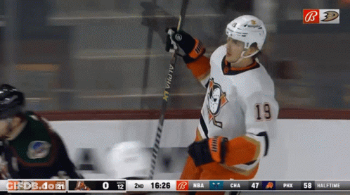 A Hockey Player With The Number 19 On His Jersey Holds A Hockey Stick GIF