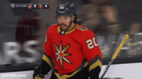 A Hockey Player With The Number 20 On His Jersey Stands On The Ice GIF