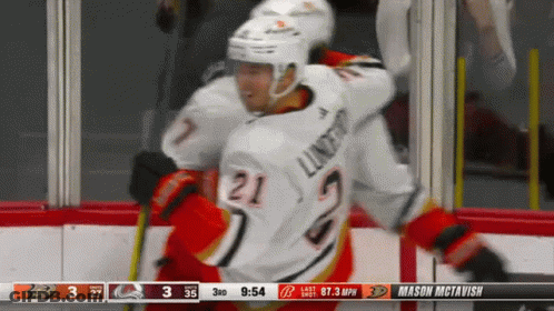 A Hockey Player With The Number 21 On His Jersey Is Being Hugged By Another Player GIF