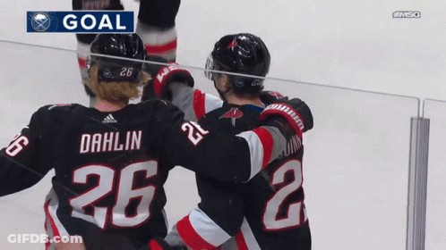 A Hockey Player With The Number 26 On His Back Is Hugging Another Player GIF
