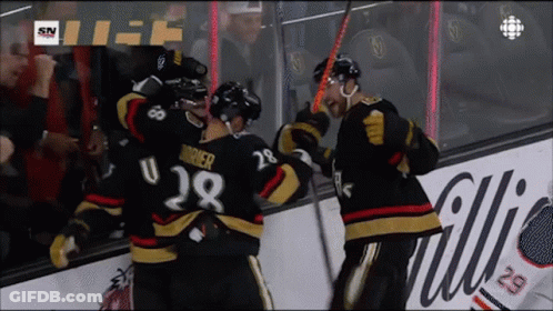 A Hockey Player With The Number 28 On His Jersey Is Being Hugged By His Teammates GIF