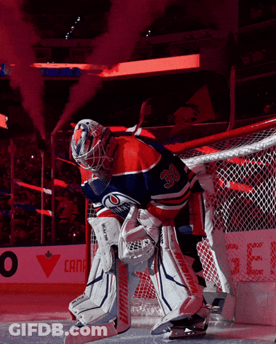 A Hockey Player With The Number 30 On His Jersey Stands In Front Of The Net GIF