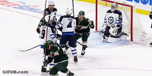 A Hockey Player With The Number 4 On His Jersey Is Surrounded By Other Players GIF
