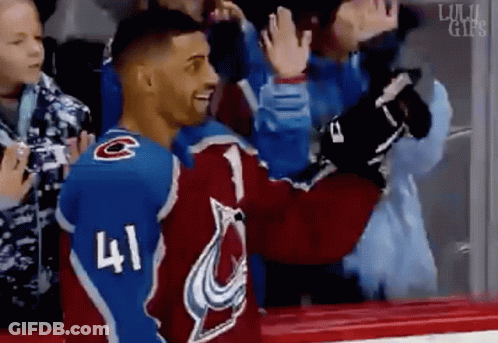 A Hockey Player With The Number 41 On His Jersey Is Giving A High Five To A Fan . GIF