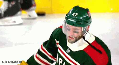A Hockey Player With The Number 47 On His Helmet Is Sitting On The Ice . GIF
