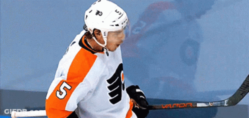 A Hockey Player With The Number 5 On His Jersey Holds A Hockey Stick GIF