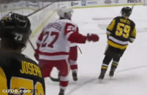 A Hockey Player With The Number 59 On His Back Stands On The Ice GIF