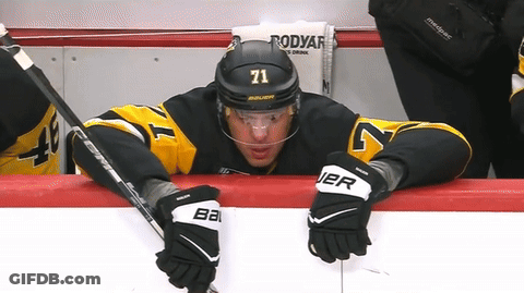 A Hockey Player With The Number 71 On His Helmet Sits On The Bench GIF